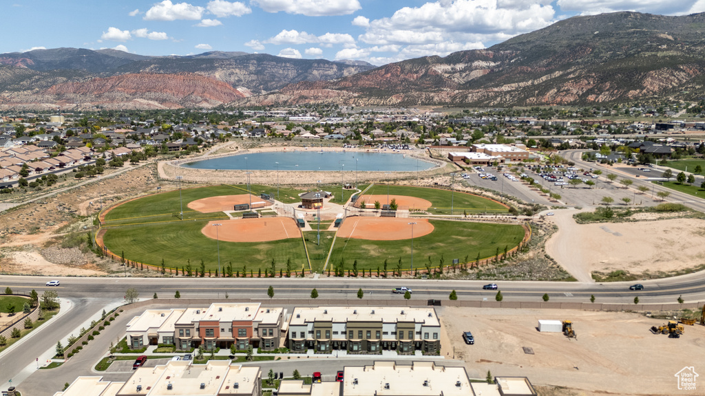 Aerial view of property and surrounding area with a water and mountain view and nearby suburban area
