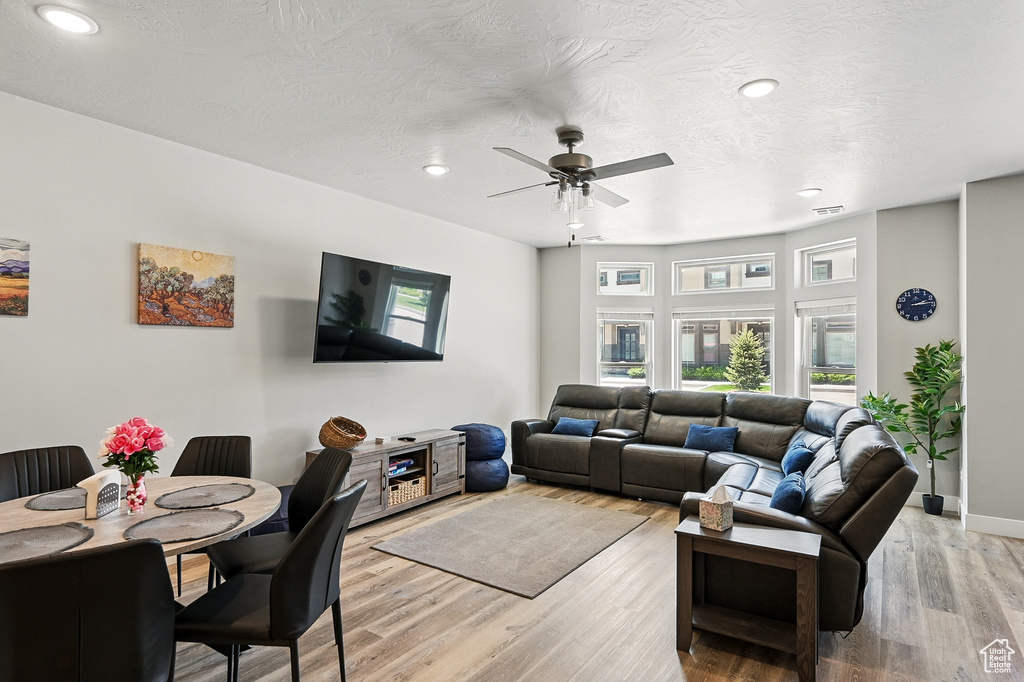Living room with recessed lighting, a ceiling fan, light wood-style floors, and baseboards