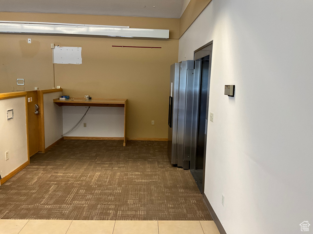 Corridor with carpet flooring and baseboards