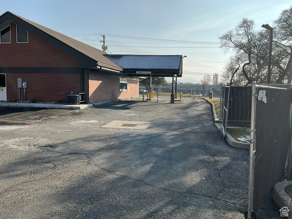 View of home's exterior featuring brick siding, uncovered parking, and cooling unit