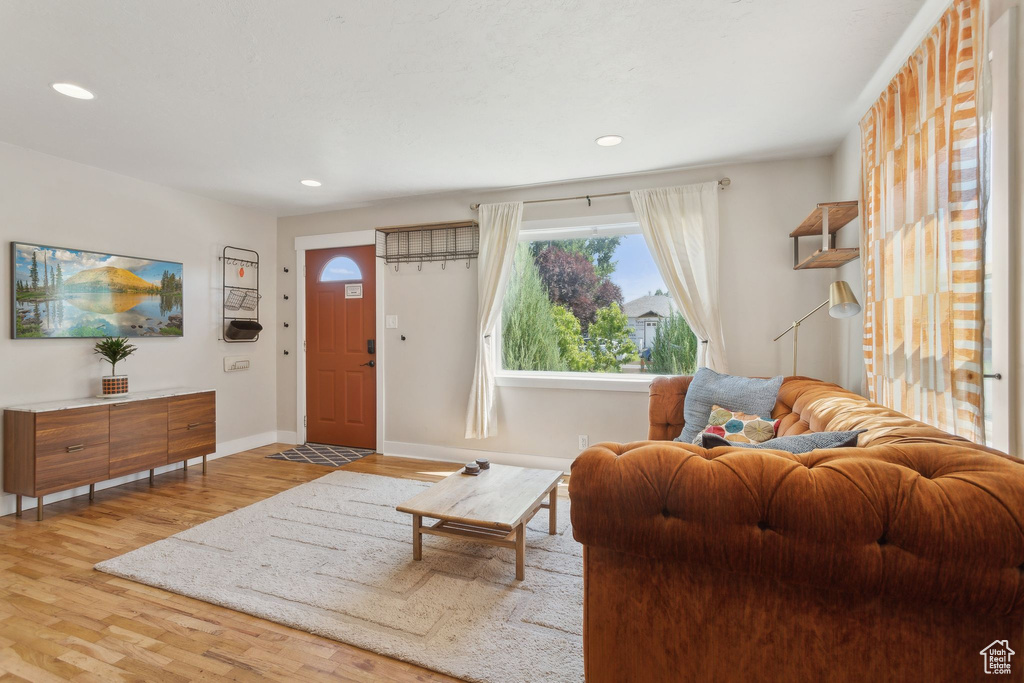 Living room with wood finished floors, baseboards, and recessed lighting