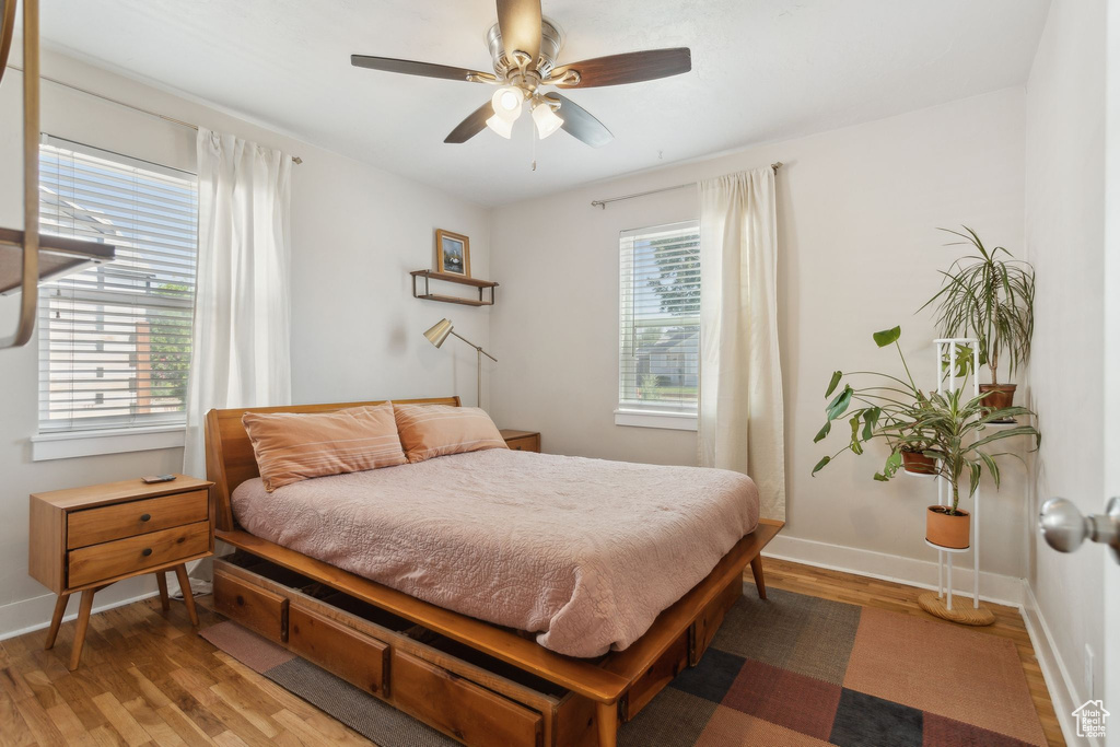 Bedroom featuring light wood-style floors, baseboards, and ceiling fan