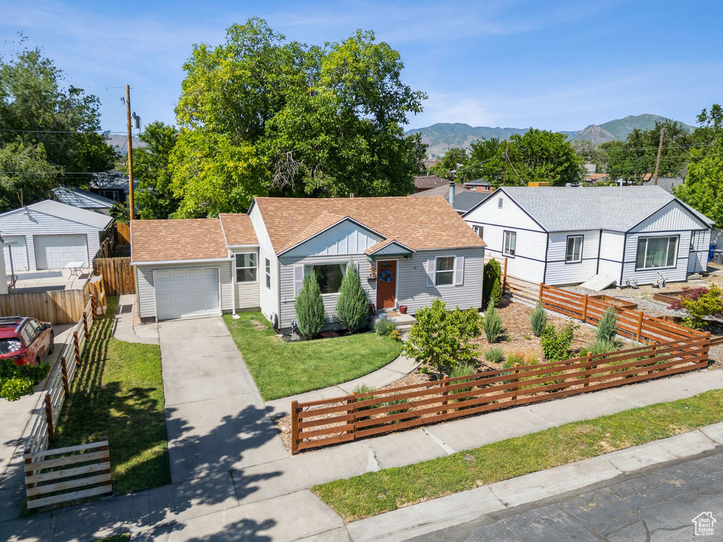 Bungalow-style house with concrete driveway, roof with shingles, a mountain view, and board and batten siding