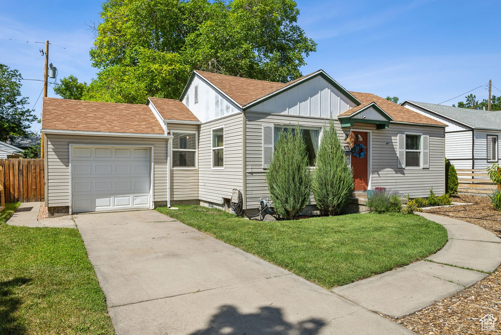 View of front facade with concrete driveway, board and batten siding, an attached garage, and a shingled roof