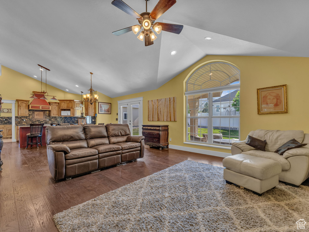 Living area with lofted ceiling, a ceiling fan, a chandelier, dark wood-style floors, and recessed lighting