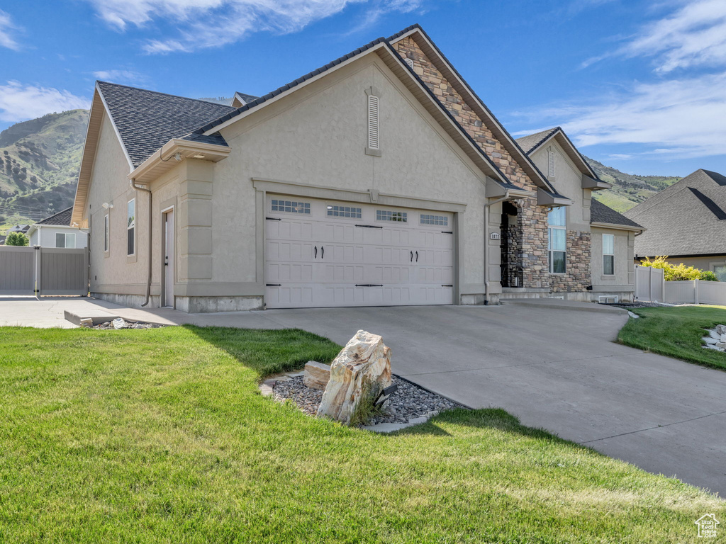 View of front of home featuring stucco siding, concrete driveway, a garage, and stone siding