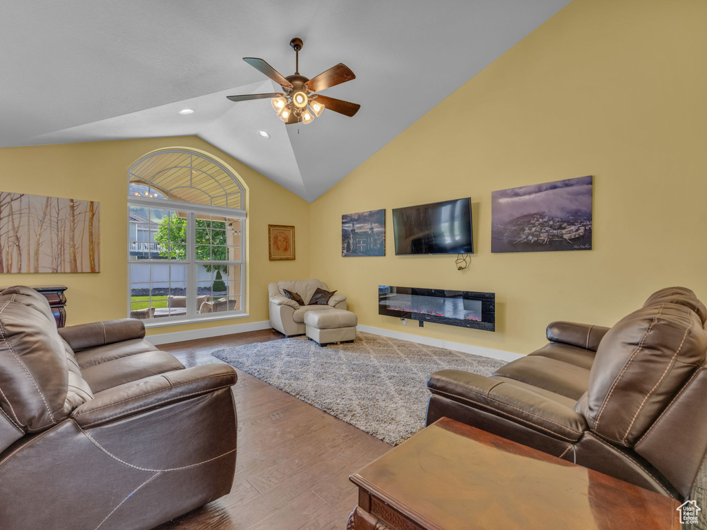 Living area with wood finished floors, a ceiling fan, vaulted ceiling, recessed lighting, and baseboards