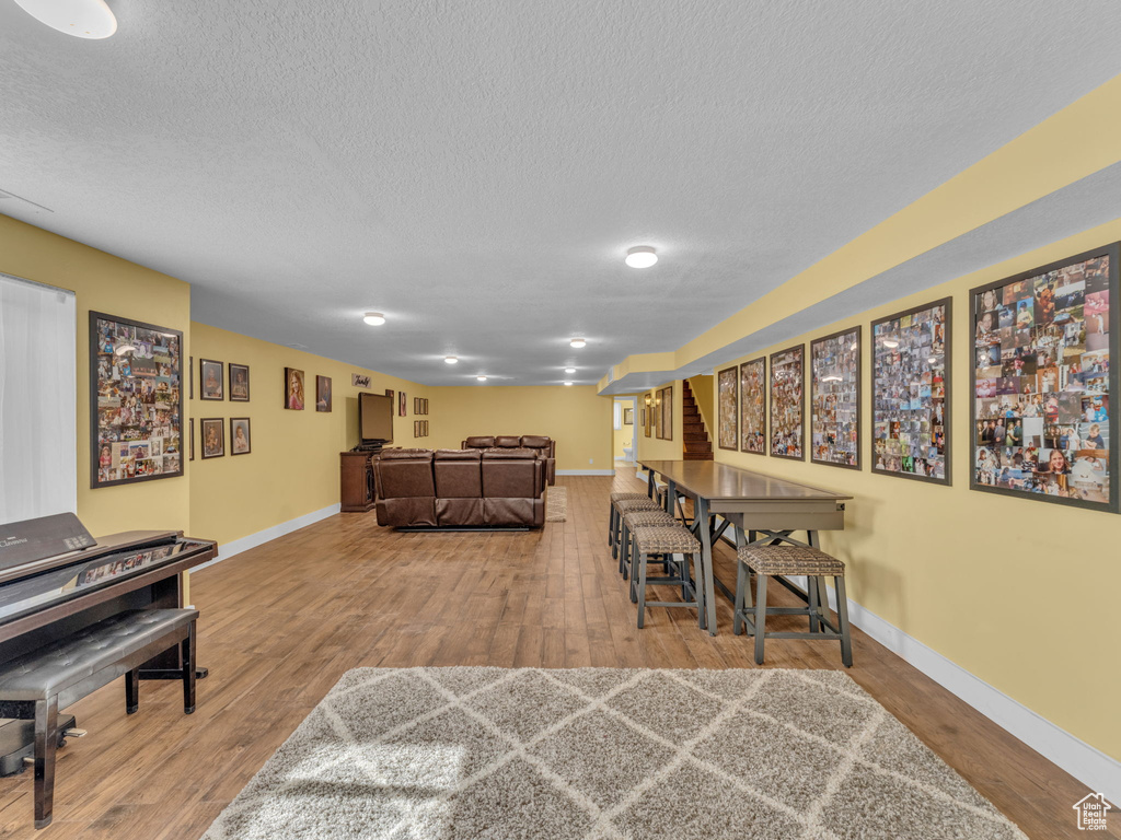 Dining area featuring a textured ceiling, wood finished floors, and baseboards