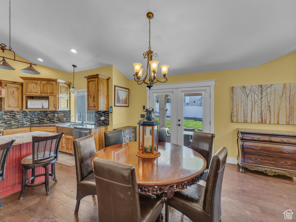 Dining area with french doors, wood finished floors, a chandelier, recessed lighting, and baseboards