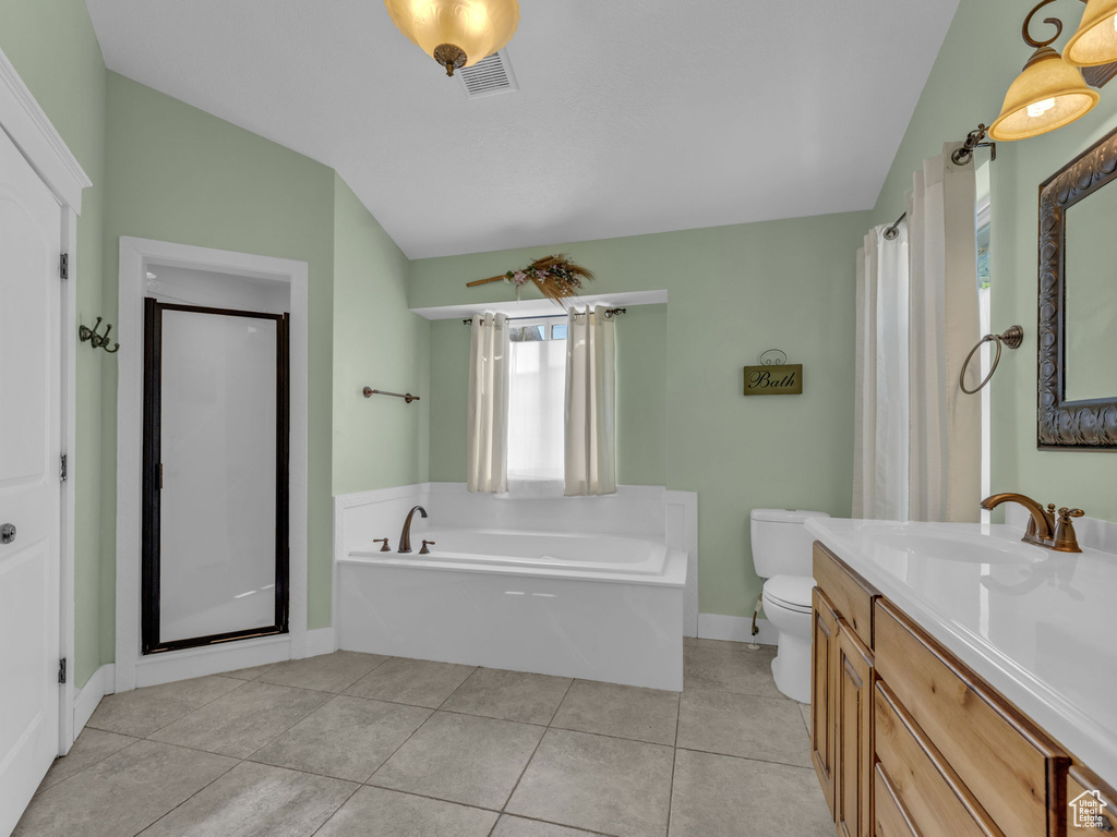 Full bath with vaulted ceiling, a garden tub, toilet, vanity, and baseboards