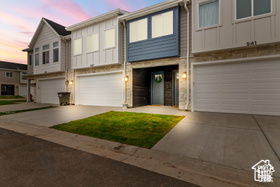 Multi unit property featuring a garage, board and batten siding, and concrete driveway