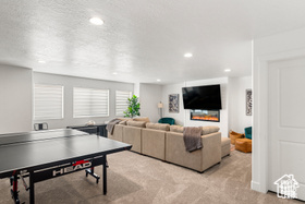 Playroom featuring light carpet, recessed lighting, and a glass covered fireplace