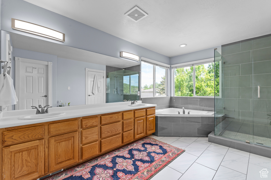 Bathroom featuring double vanity, a bath, and a shower stall