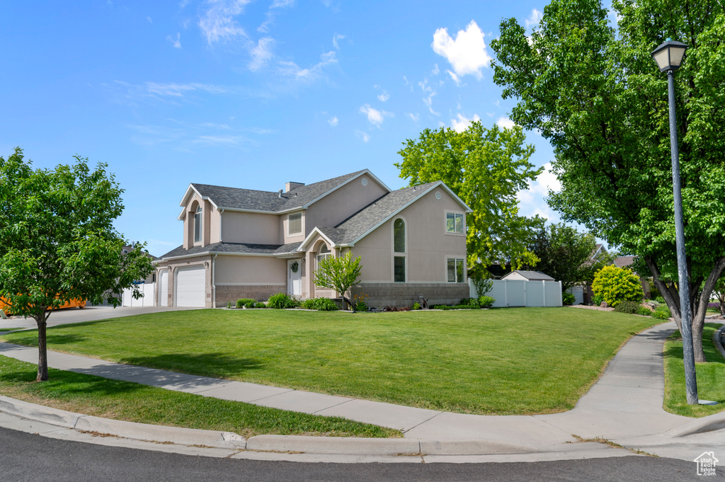 Traditional home featuring an attached garage, concrete driveway, and stucco siding