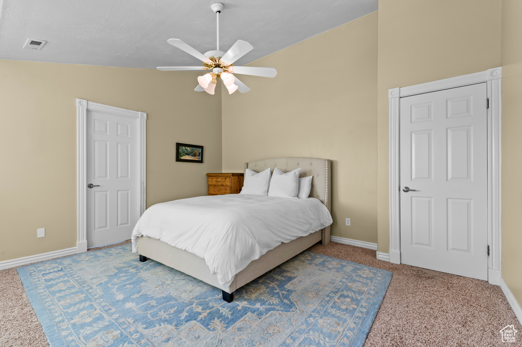 Bedroom with carpet floors, vaulted ceiling, baseboards, and a ceiling fan