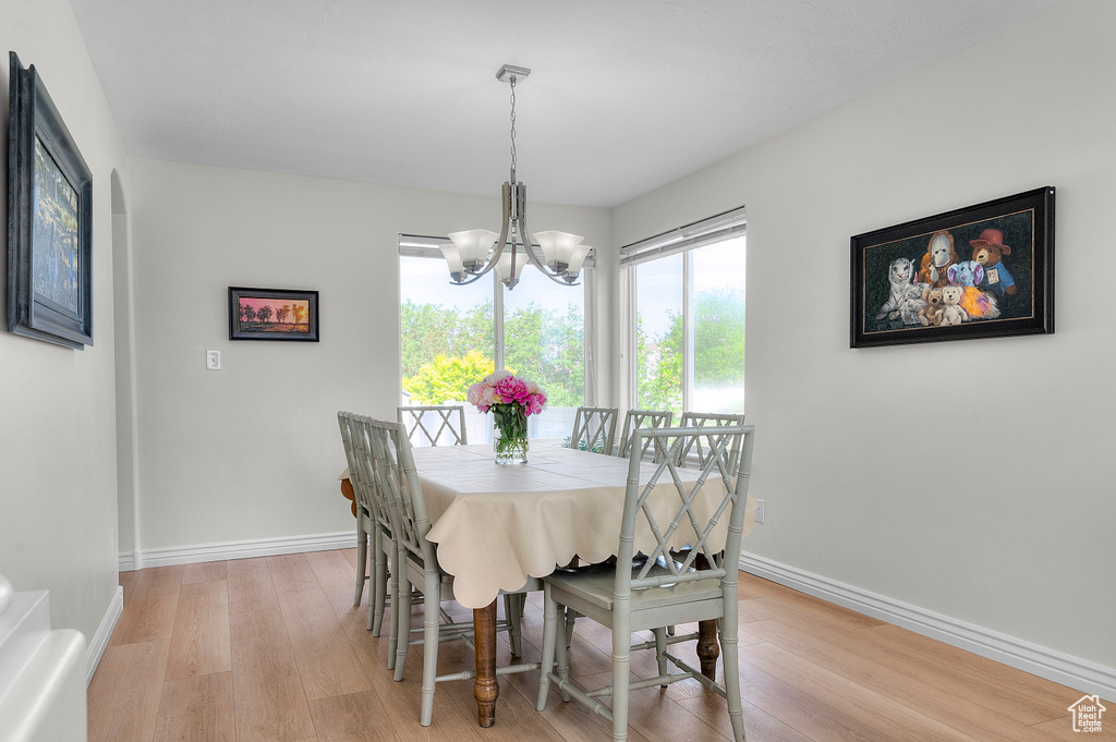 Dining space featuring a chandelier, light wood-style floors, and baseboards