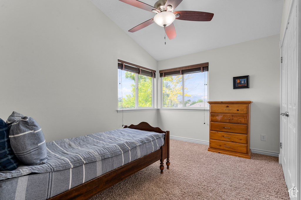 Bedroom with carpet, baseboards, vaulted ceiling, and ceiling fan