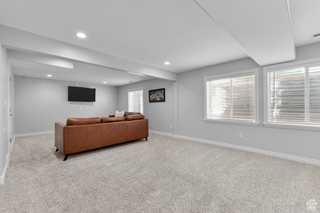 Living area featuring baseboards, light colored carpet, and recessed lighting