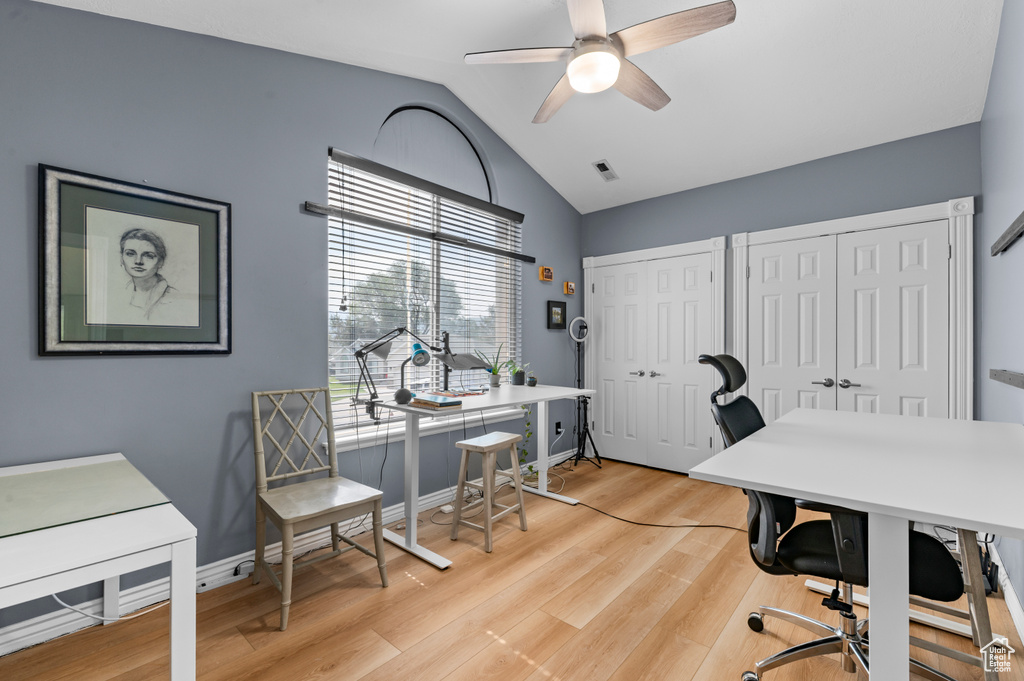 Office space featuring vaulted ceiling, ceiling fan, light wood-style flooring, and baseboards