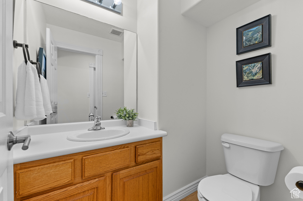 Half bath featuring toilet and vanity