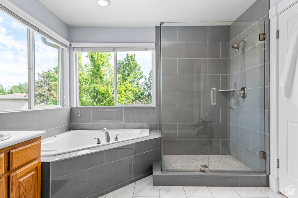 Full bath featuring a garden tub, a stall shower, and vanity
