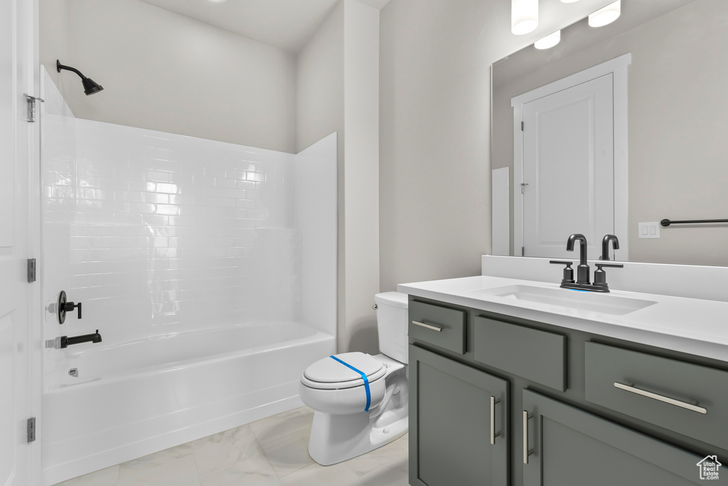 Full bathroom with  shower combination, vanity, toilet, and marble finish floors