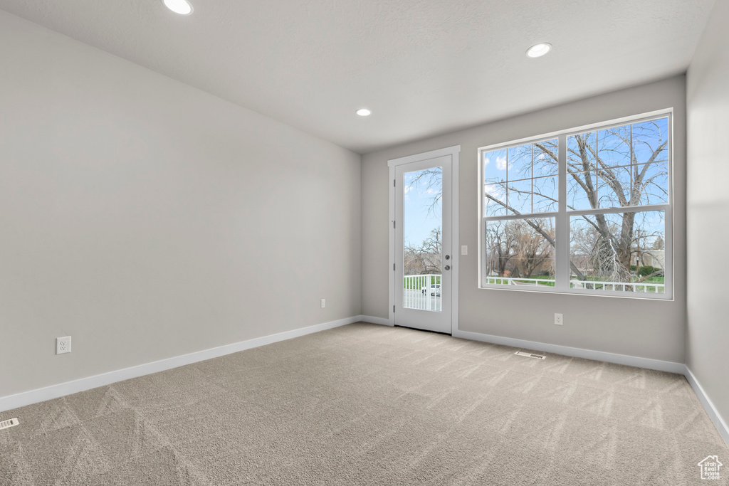 Carpeted empty room with plenty of natural light, baseboards, and recessed lighting