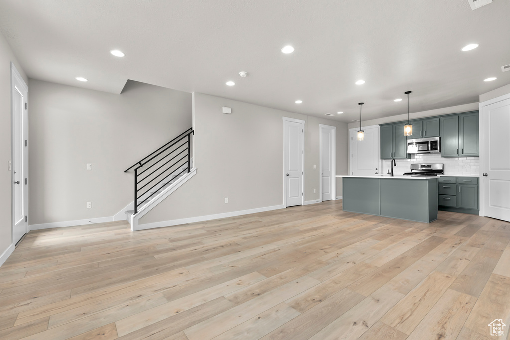 Kitchen featuring stainless steel appliances, a sink, recessed lighting, baseboards, and tasteful backsplash