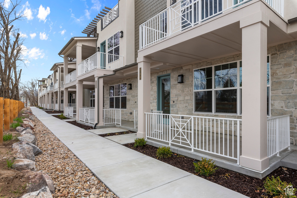 View of exterior entry featuring a porch and stone siding