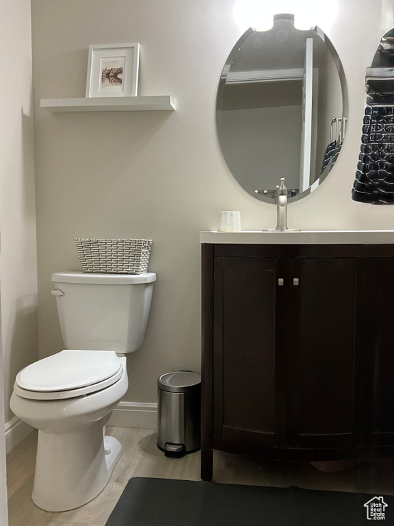 Half bath with toilet, vanity, and baseboards