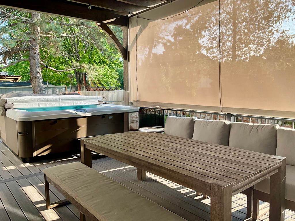 Deck featuring a hot tub and outdoor dining area
