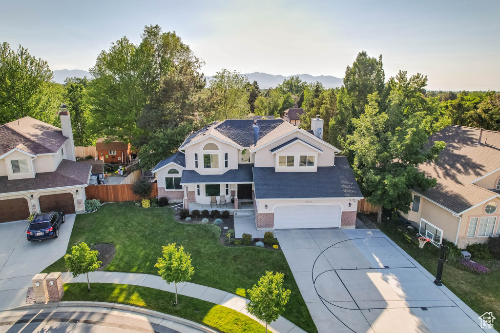 View of front facade with driveway, a porch, a mountain view, and brick siding