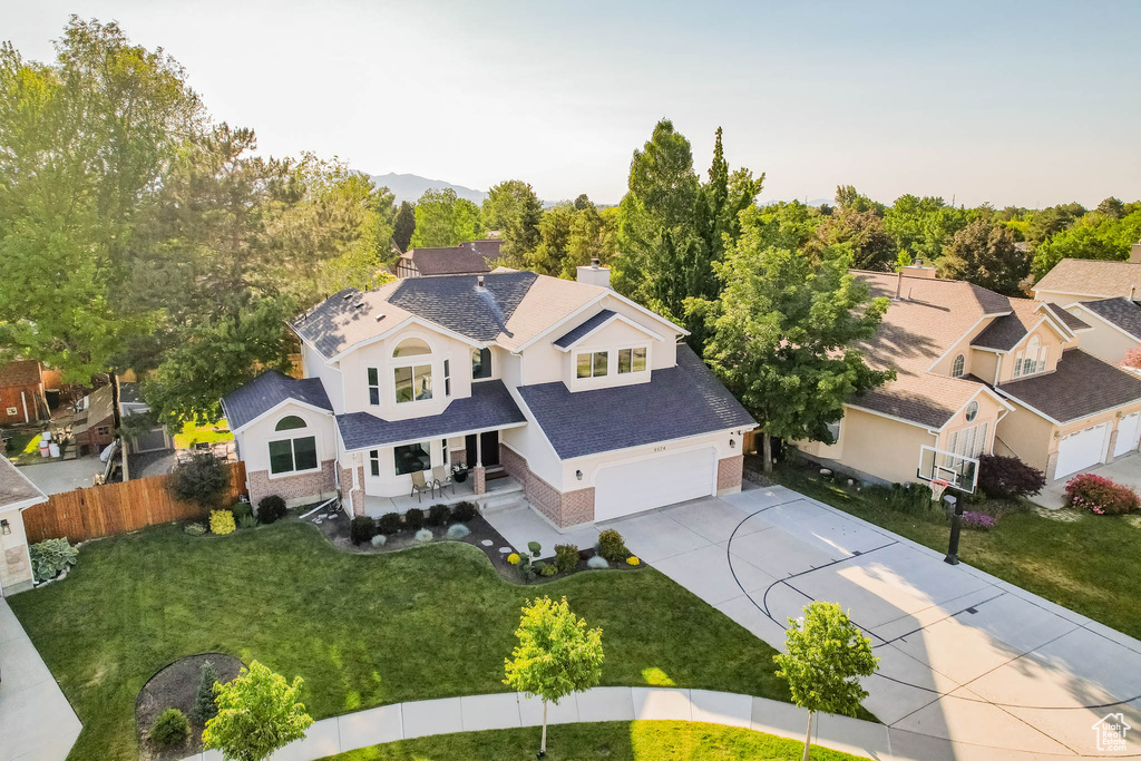 View of front of home featuring concrete driveway, covered porch, an attached garage, roof with shingles, and a chimney