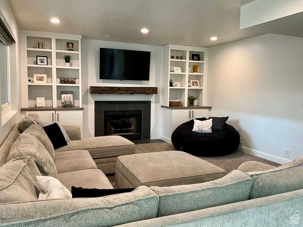Carpeted living area featuring recessed lighting, a fireplace, and baseboards