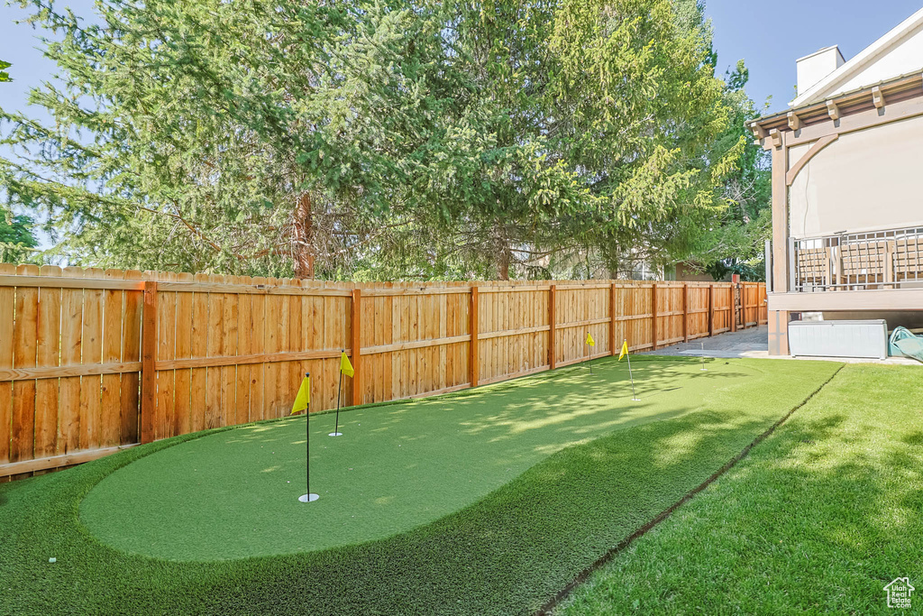 Fenced backyard with a putting area