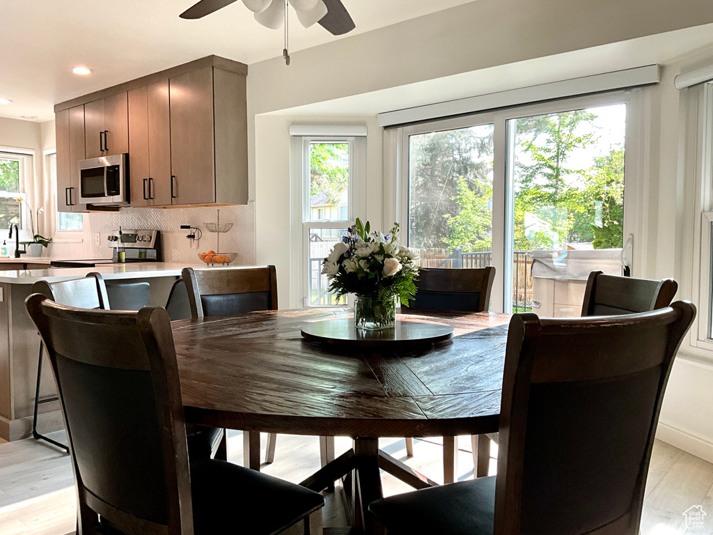Dining area with ceiling fan, light wood-style flooring, and recessed lighting