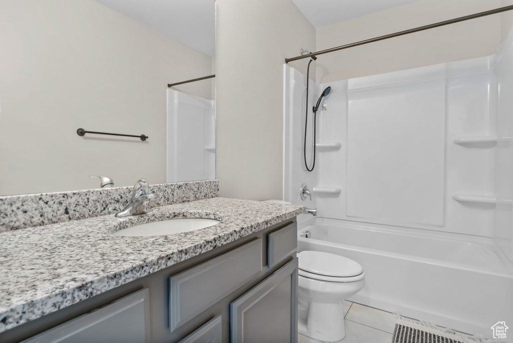 Full bathroom with vanity, tile patterned flooring, toilet, and shower / tub combination