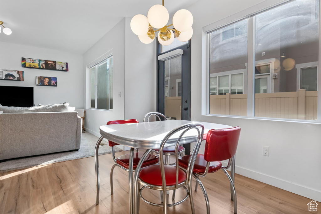 Dining space with wood finished floors, baseboards, and a chandelier