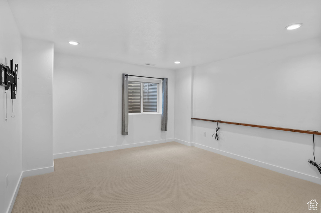 Spare room featuring light carpet, recessed lighting, and baseboards