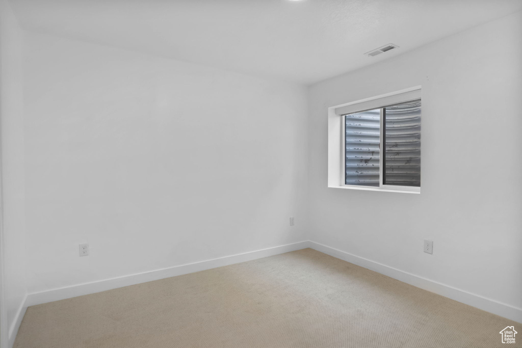 Unfurnished room featuring baseboards and light colored carpet