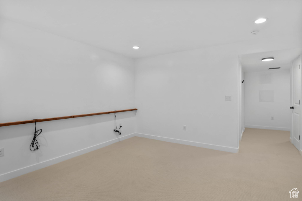 Empty room featuring light colored carpet, baseboards, and recessed lighting