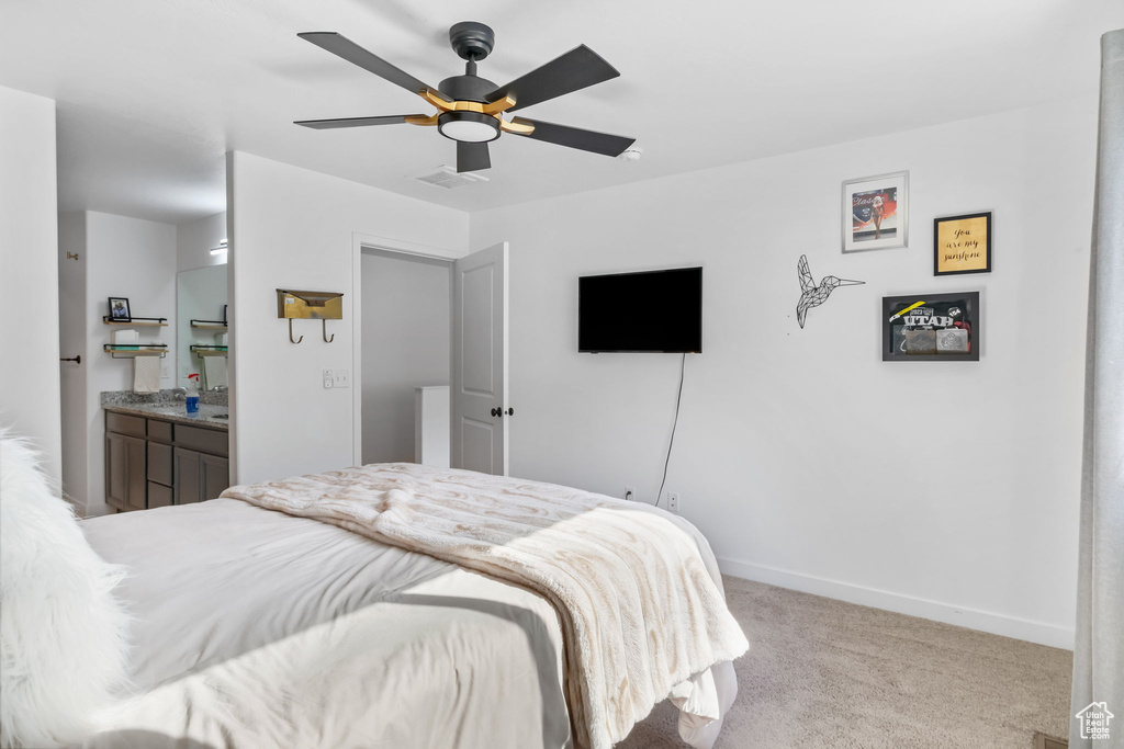 Bedroom featuring carpet flooring, baseboards, a ceiling fan, and connected bathroom
