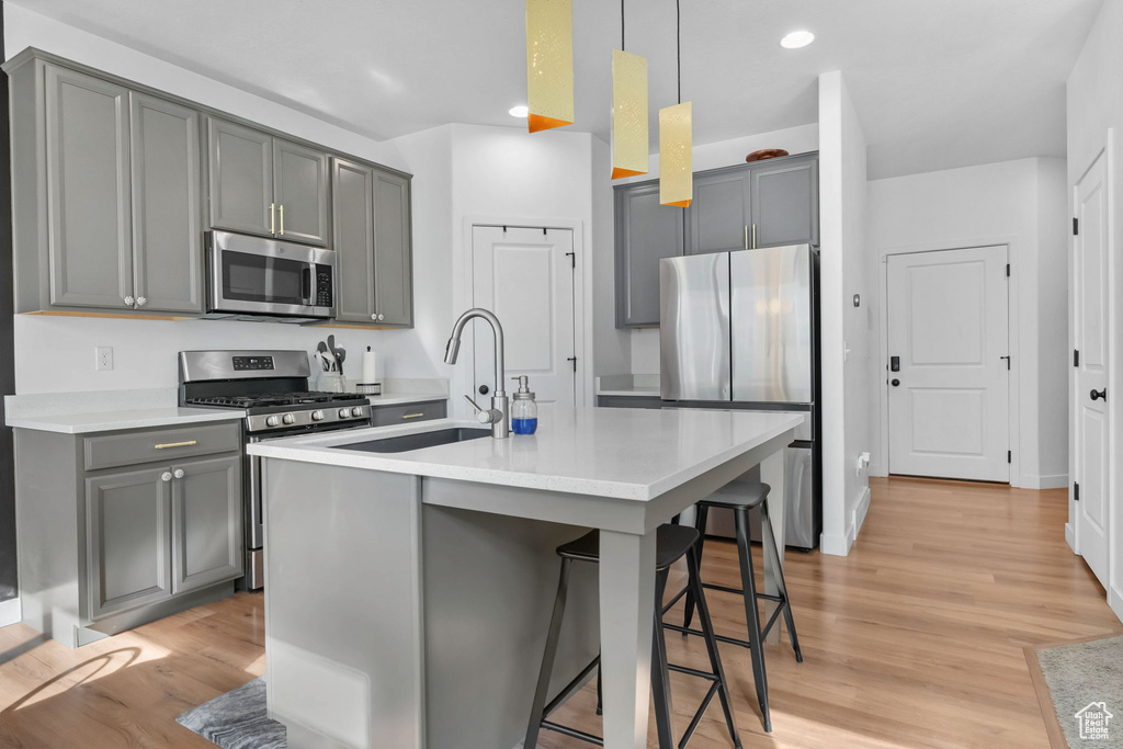 Kitchen featuring stainless steel appliances, a sink, gray cabinetry, and recessed lighting