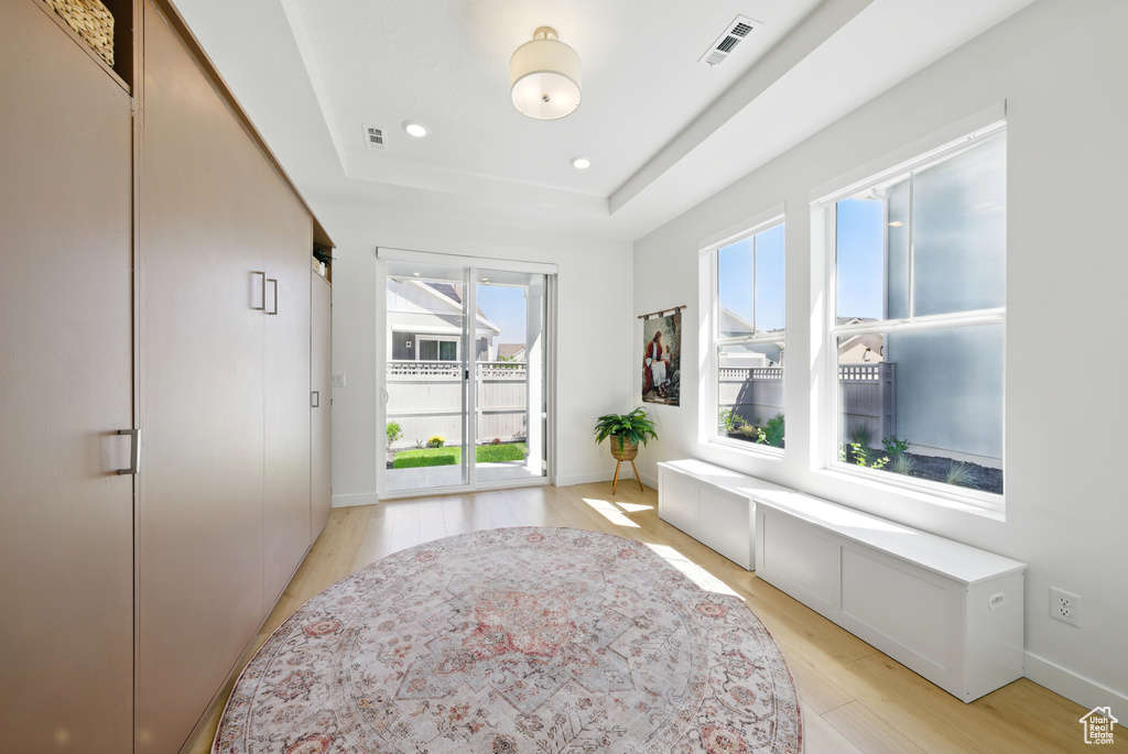 Sitting room featuring light wood-style floors, a raised ceiling, baseboards, and recessed lighting