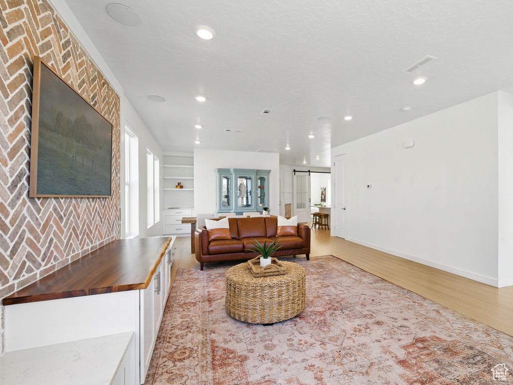 Living area featuring light wood-style floors, recessed lighting, and baseboards