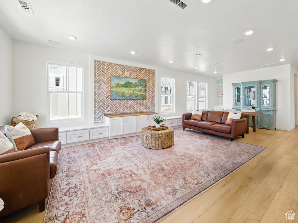Living room with light wood finished floors and recessed lighting