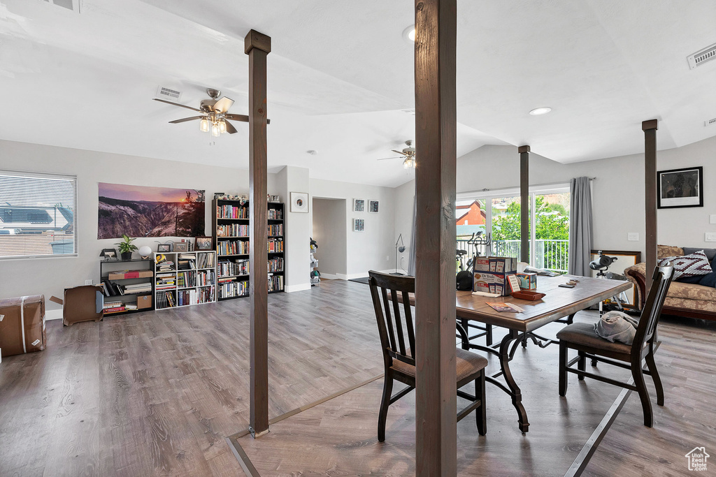 Dining area with a ceiling fan, lofted ceiling, baseboards, and wood finished floors