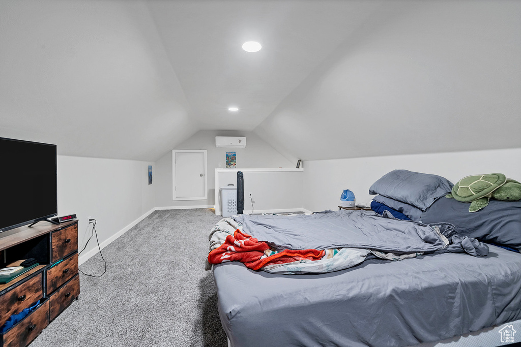 Carpeted bedroom with baseboards, lofted ceiling, recessed lighting, and a wall unit AC