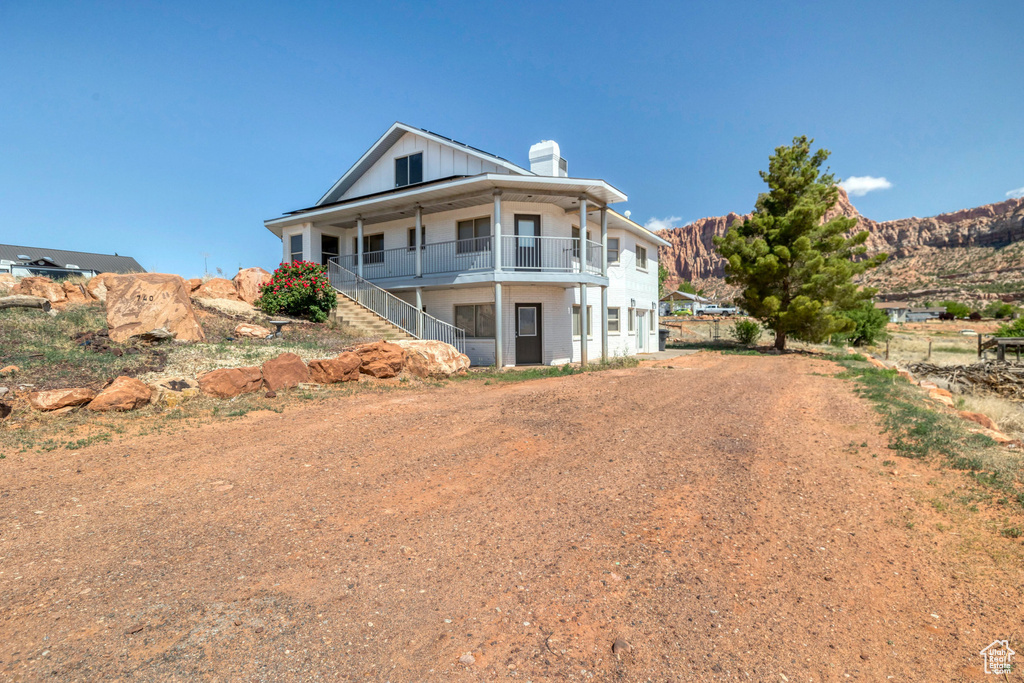 Rear view of property featuring stairs, a chimney, and a mountain view