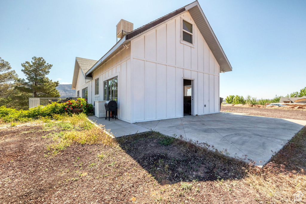 Rear view of property featuring board and batten siding and a patio